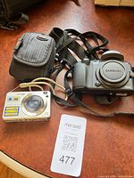 Lot overview showing Samsung camera body, Sony camera, case, straps