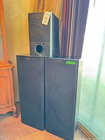 Two tall Sony speakers with smaller Sony speaker on top