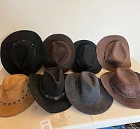 Seven of the eight hats arranged on table showing colours and styles