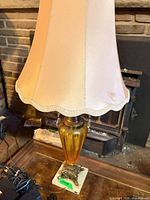 Lamp with cream bell shade on table showing overall appearance