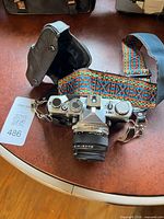 Full view of OM-1 camera with lens, strap and leather case piece