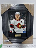 Front view of framed Brady Tkachuk photo showing mat, frame, and shrink wrap