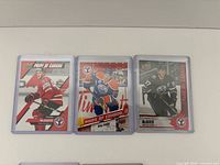 Front view of three Connor McDavid cards in sleeves