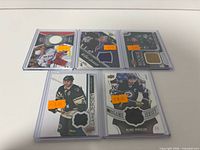Front view of five jersey cards in sleeves