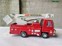 Left side view showing entire Buddy L Snorkel fire truck with boom raised