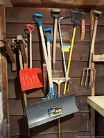All eight long-handled tools hanging on shed wall