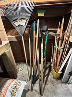 Group of long-handle garden tools with compost bag