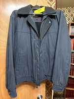 Front view of Rockport men's dark navy coat on hanger showing zip and snap front, collar detail and overall condition