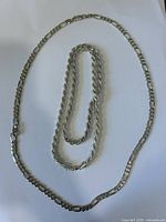 Two sterling silver chains laid out to show style and length