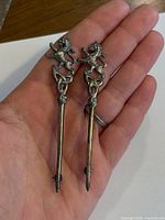Front view of both silver kilt pins in hand