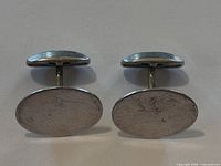 Front view of both cufflinks showing oval faces