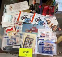 Overview of assorted sealed commemorative stamp sets, souvenir sheets and blocks on table