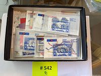 Top view of box containing numerous glassine envelopes filled with mint Canadian commemorative stamps