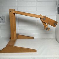 Side view of wooden embroidery stand showing base and adjustable arm