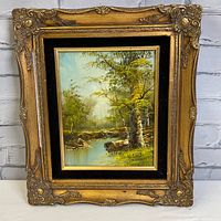 Front view of framed forest and stream oil painting