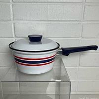 Side view showing stripes, handle, and lid
