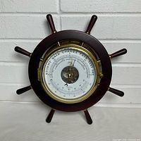 Front view of Schatz ship wheel barometer showing dial and spokes