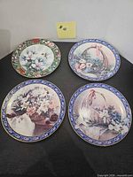 Four decorative plates displayed together