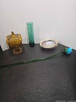 All four items: amber candy dish with lid, green bud vase, abalone shell, blue glass rose