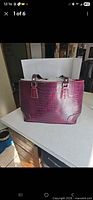 Front view of burgundy croc-embossed handbag