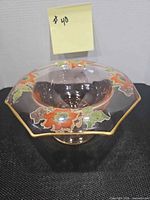 Top angled view showing floral enamel decoration and gold rim on pink Depression glass candy dish
