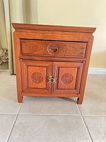 Front view showing drawer, cabinet doors, pulls, overall finish