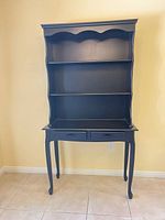 Full view of black distressed hutch desk showing shelves, drawers, and cabriole legs