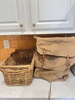 Backpack and wicker basket side by side