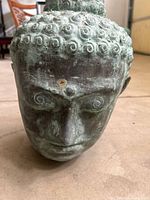 Front angled view of bronze Buddha head showing patina and facial detail