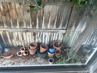Group of assorted pots along fence