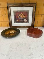 Framed print, decorative plate and wooden apple dish grouped together