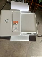 Top view showing HP logo, scanner lid, and white finish