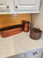 Group shot of copper planter, pitcher and wall pocket