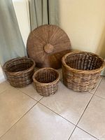 Group shot showing three wicker baskets and round woven wall piece