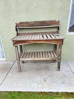 Full view of wooden potting bench against wall