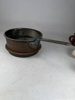 Full view of copper pan showing handle and tin interior