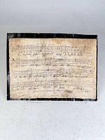 Full view of mounted handwritten music sheet