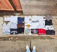 All 23 shirts laid out in four rows on plywood