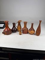 Group of seven woodturned vases arranged side by side