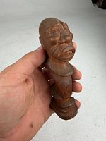 Front view of carved wooden figurine showing facial details