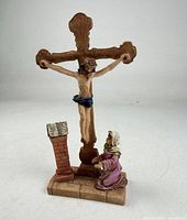 Front view of crucifix figurine with Bible stand and kneeling woman