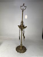 Full view of brass oil lamp on tall stand with accessories