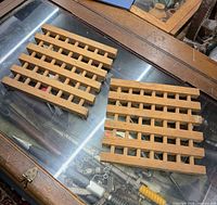 Pair of square wooden lattice stands on glass surface