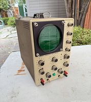 Front view showing CRT screen and control panel with knobs and jacks