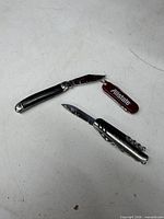 Overview of three pocket knives opened for feature visibility