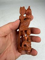 Front view of sandalwood bird carving held in hand