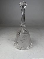 Front view of cut crystal bell showing etched rose panel and faceted handle