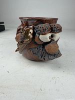 Front view of ceramic mug showing sculpted facial features