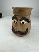 Front view showing sculpted face details and moustache guard