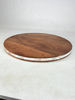Full view of the round wooden platter showing surface and side inlay